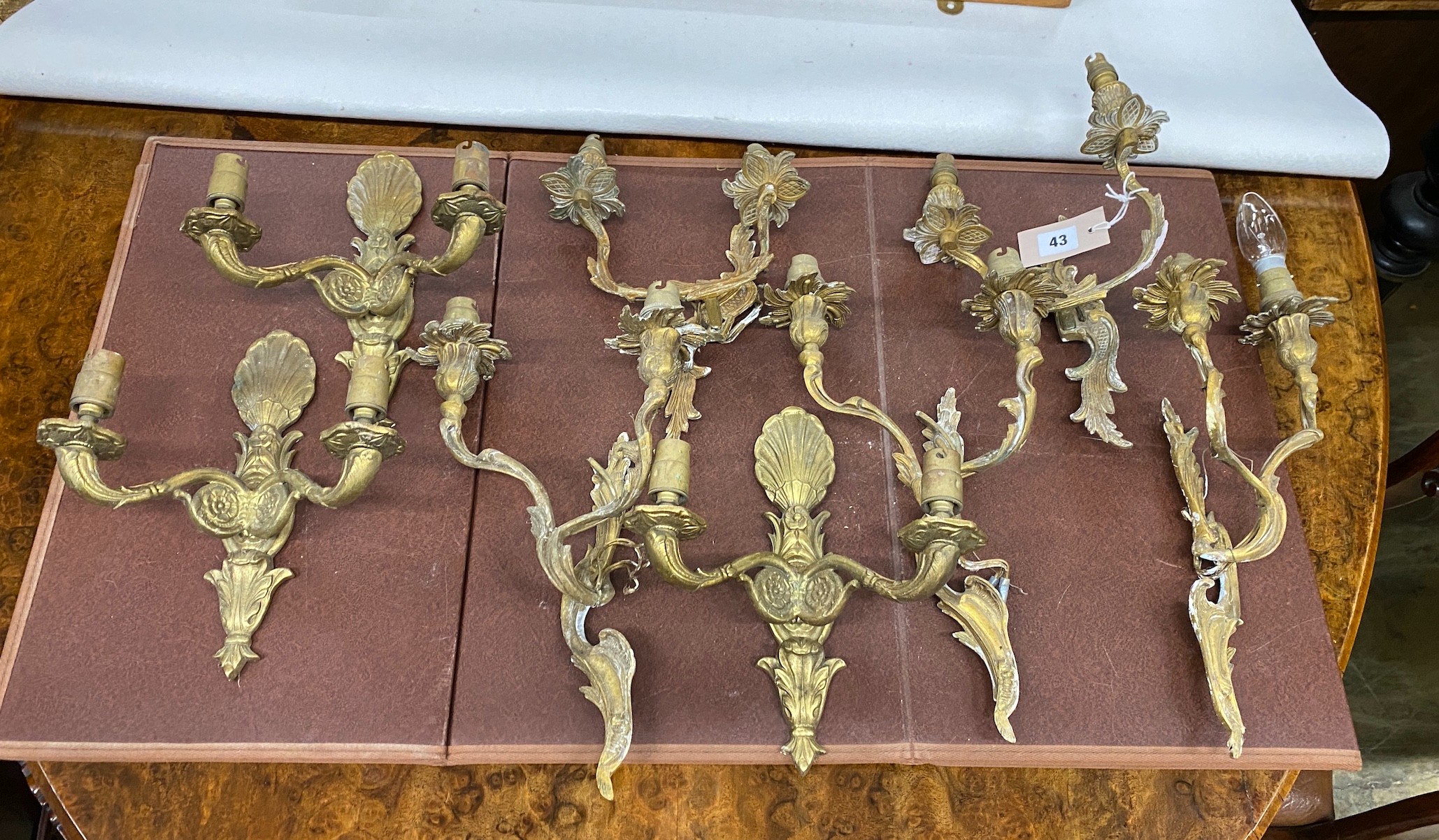 Eight assorted cast brass twin branch wall lights, largest height 37cm